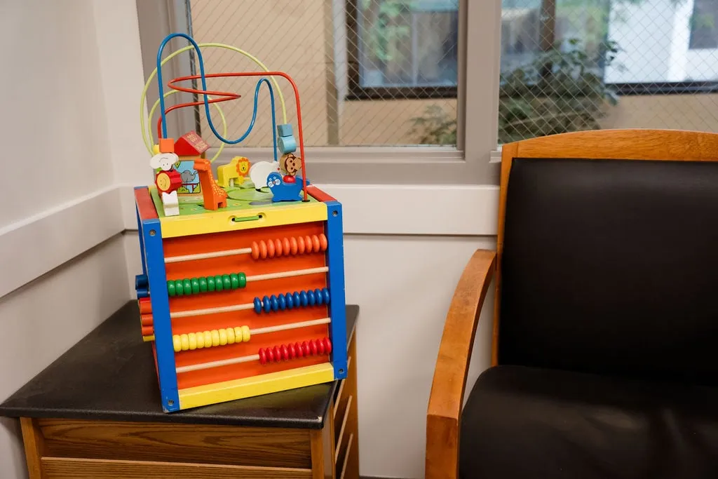 A children’s activity cube on a side table in the waiting room