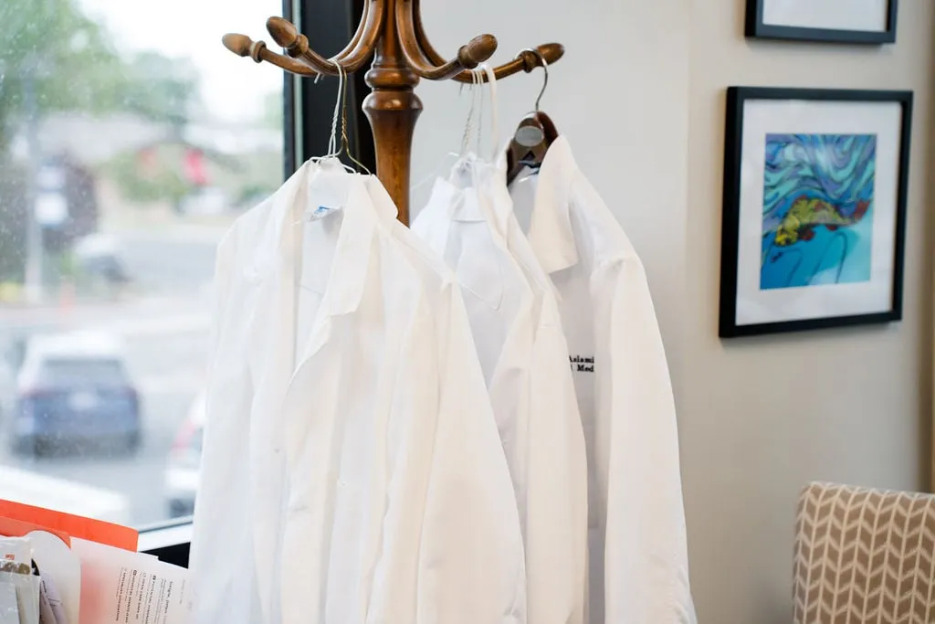 White coats hanging by a window
